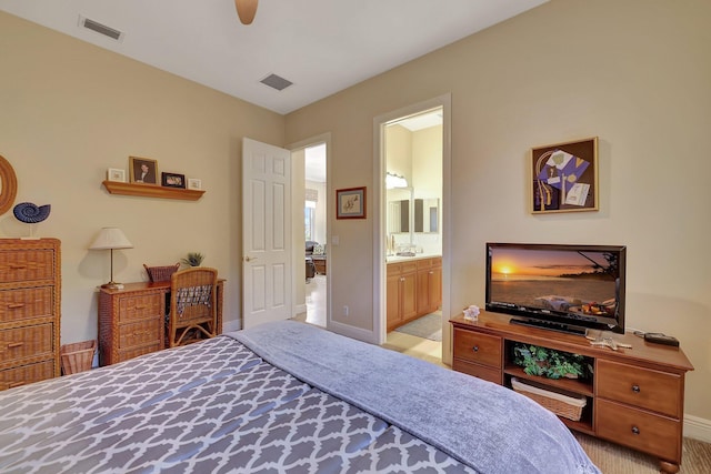 bedroom with baseboards, visible vents, and ensuite bath