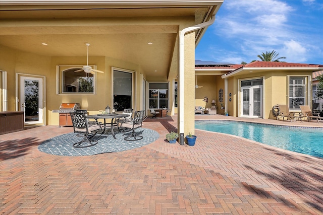 outdoor pool with a ceiling fan and a patio