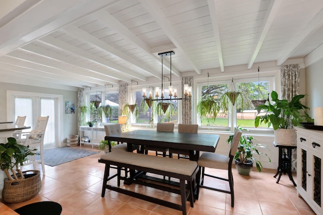 tiled dining room featuring a chandelier, beam ceiling, and french doors