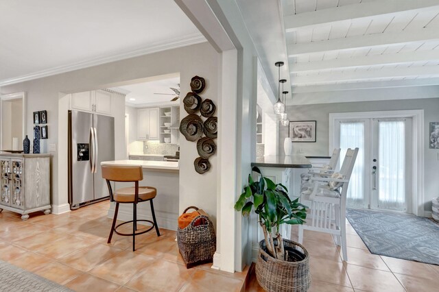 interior space with beam ceiling, light tile patterned flooring, wood ceiling, and french doors