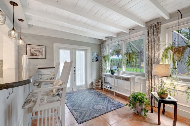 sunroom / solarium featuring beamed ceiling and french doors