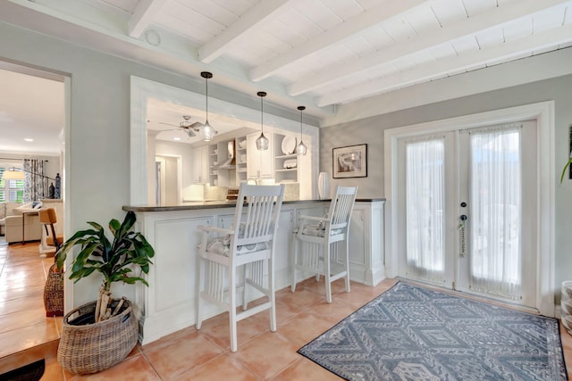 kitchen with pendant lighting, french doors, white cabinets, beamed ceiling, and kitchen peninsula