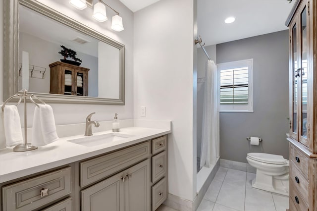 bathroom featuring curtained shower, tile patterned flooring, vanity, and toilet