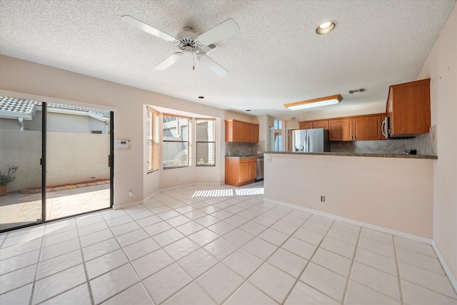 interior space featuring light tile patterned floors, a textured ceiling, and ceiling fan