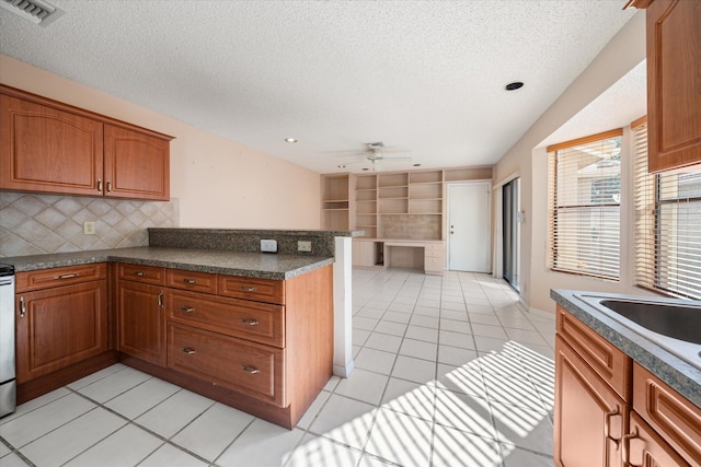 kitchen with ceiling fan, decorative backsplash, light tile patterned floors, a textured ceiling, and kitchen peninsula