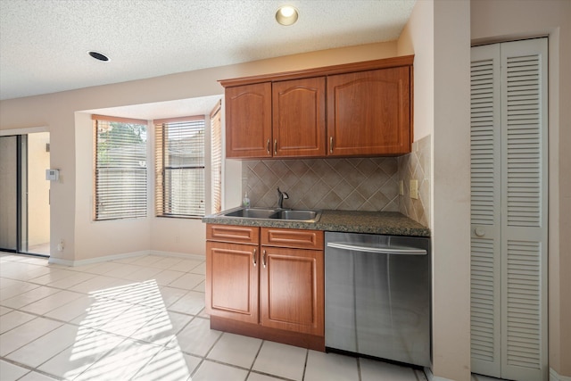 kitchen featuring decorative backsplash, stainless steel dishwasher, a textured ceiling, sink, and light tile patterned floors