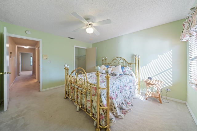 bedroom with light carpet, a textured ceiling, and ceiling fan