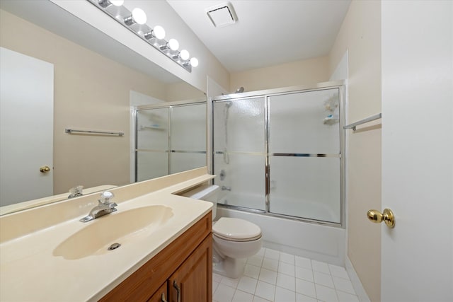 full bathroom featuring combined bath / shower with glass door, tile patterned floors, vanity, and toilet