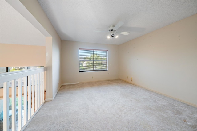 unfurnished bedroom with ceiling fan, light colored carpet, and a textured ceiling