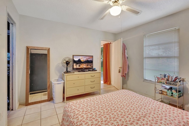 tiled bedroom featuring ceiling fan and a textured ceiling