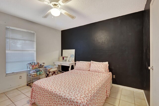 tiled bedroom featuring a textured ceiling and ceiling fan