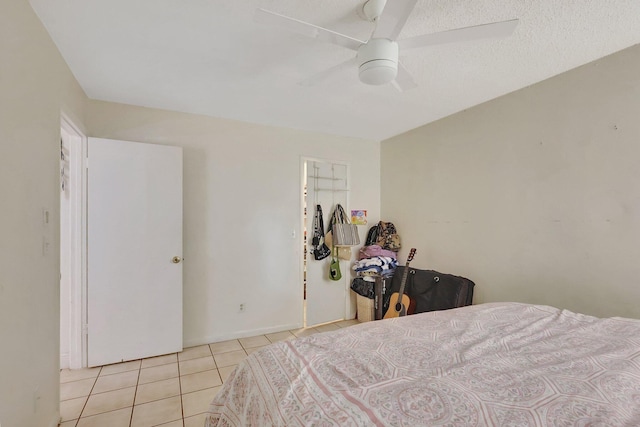 tiled bedroom featuring ceiling fan and a textured ceiling