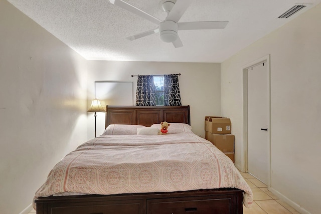 tiled bedroom featuring ceiling fan and a textured ceiling