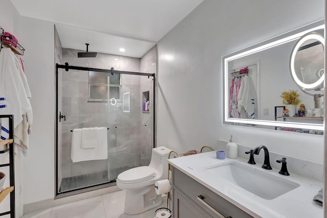 bathroom with tile patterned flooring, vanity, an enclosed shower, and toilet