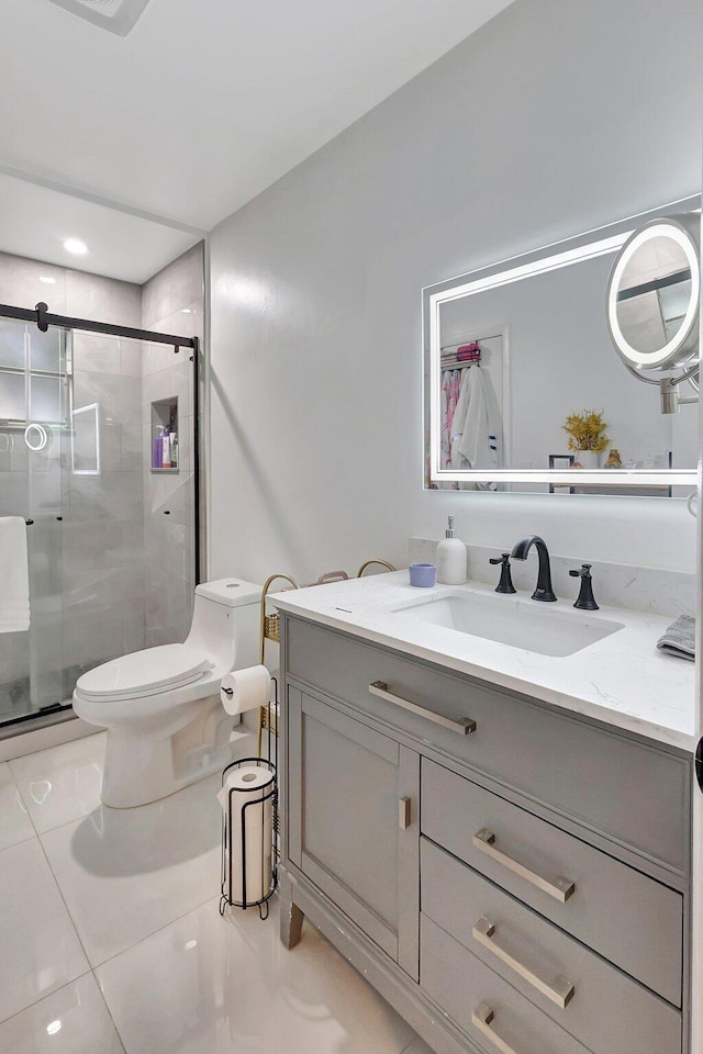 bathroom featuring toilet, vanity, tile patterned floors, and an enclosed shower