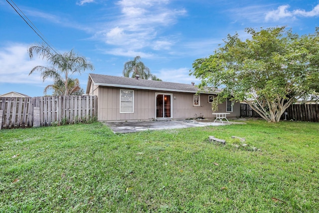 rear view of property with a lawn and a patio