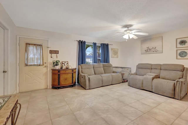 living room featuring ceiling fan, light tile patterned floors, and a textured ceiling