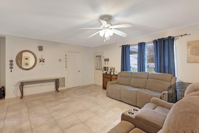 tiled living room with ceiling fan and a textured ceiling