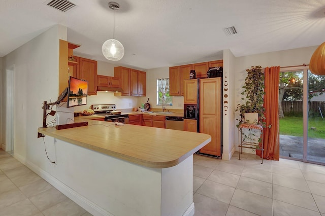 kitchen with sink, light tile patterned floors, appliances with stainless steel finishes, decorative light fixtures, and kitchen peninsula