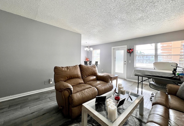 living room featuring hardwood / wood-style floors, a notable chandelier, and a textured ceiling