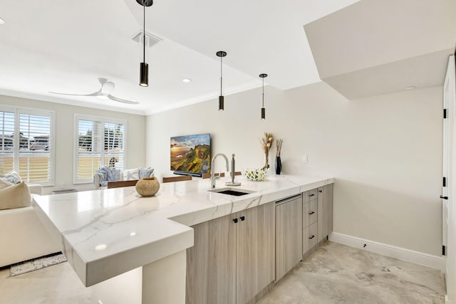 kitchen featuring light stone countertops, sink, kitchen peninsula, decorative light fixtures, and light brown cabinetry