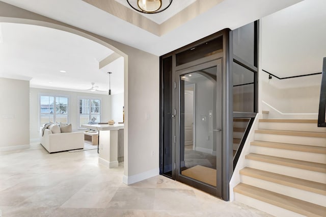 stairs featuring a raised ceiling