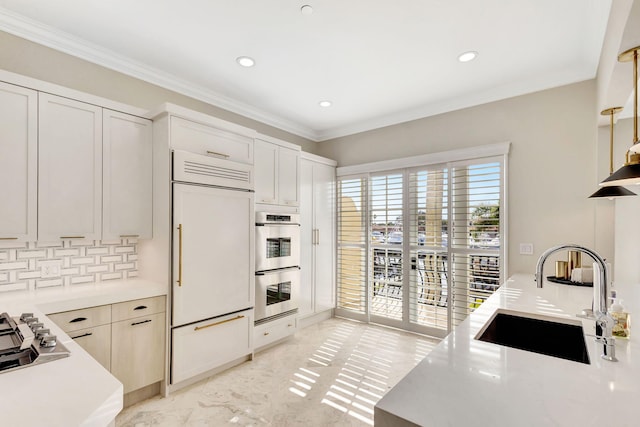 kitchen featuring sink, backsplash, crown molding, white cabinets, and appliances with stainless steel finishes