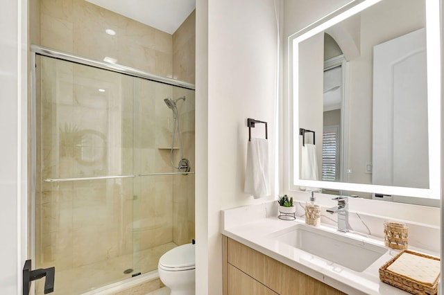 bathroom featuring vanity, toilet, and walk in shower