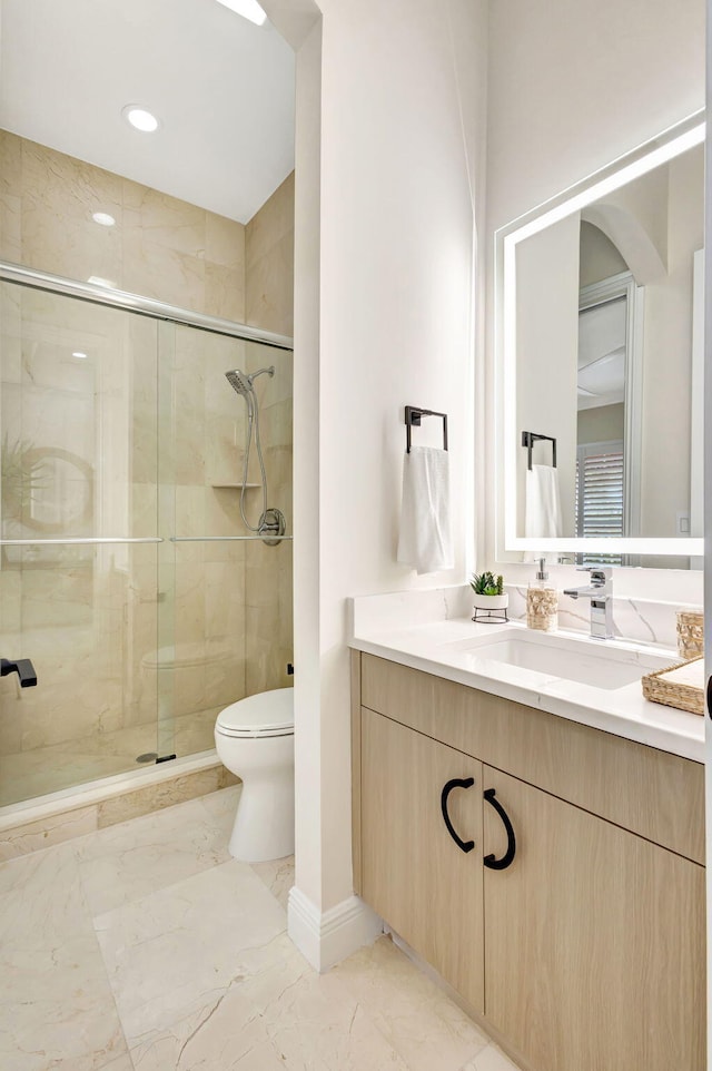 bathroom featuring an enclosed shower, vanity, and toilet