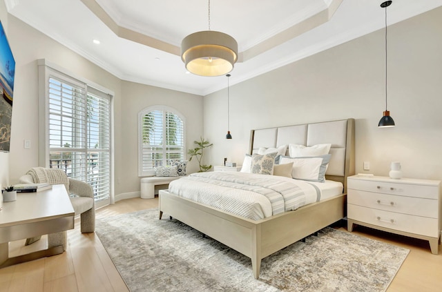 bedroom with a raised ceiling, crown molding, and hardwood / wood-style floors