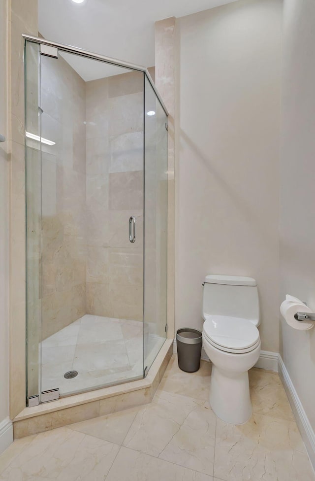 bathroom featuring toilet and a shower with door