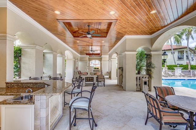 view of patio with area for grilling, ceiling fan, and an outdoor wet bar