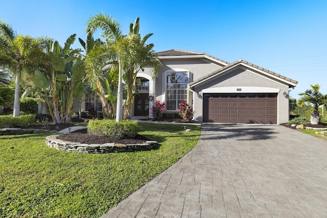 mediterranean / spanish-style home with a garage and a front lawn