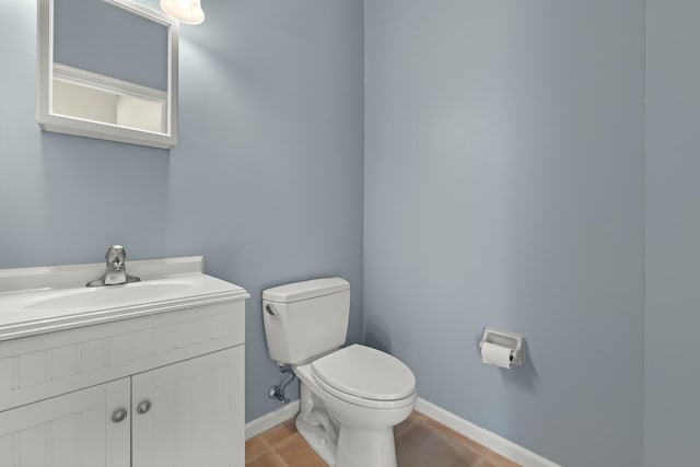 bathroom with toilet, vanity, and tile patterned floors