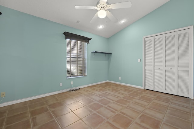 unfurnished bedroom featuring vaulted ceiling, ceiling fan, light tile patterned flooring, and a closet