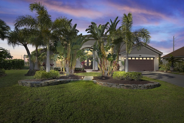 view of front of house with a yard and a garage