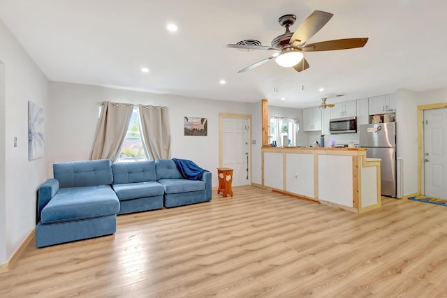 living room with ceiling fan and light wood-type flooring