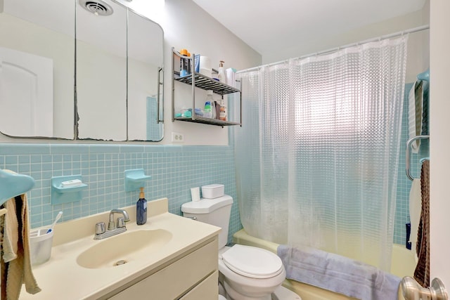 full bathroom with vanity, shower / bath combination with curtain, tile walls, and toilet