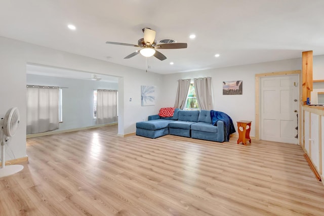 living room featuring ceiling fan and light hardwood / wood-style floors