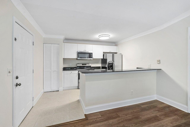 kitchen featuring kitchen peninsula, white cabinetry, light hardwood / wood-style flooring, and stainless steel appliances