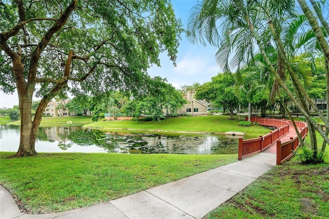 view of property's community with a yard and a water view