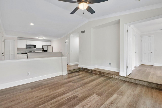 unfurnished living room featuring wood-type flooring, ceiling fan, and ornamental molding