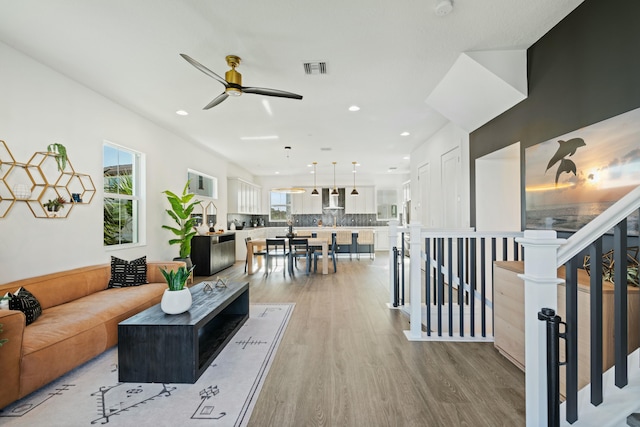 living room featuring ceiling fan and light hardwood / wood-style floors