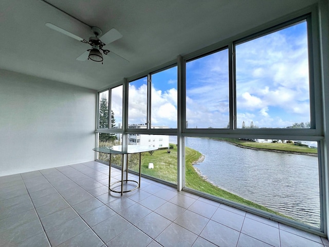 unfurnished sunroom featuring ceiling fan, a healthy amount of sunlight, and a water view