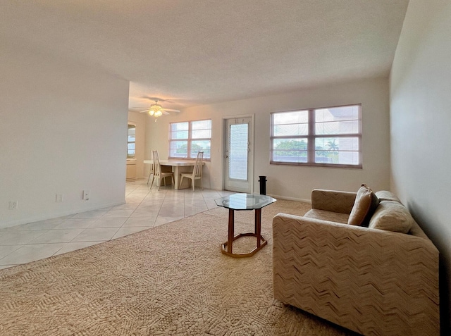 tiled living room featuring ceiling fan and a textured ceiling