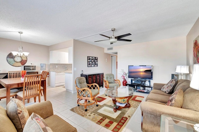 living room with ceiling fan with notable chandelier, a textured ceiling, and light tile patterned flooring