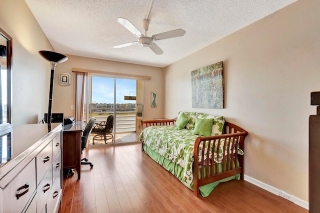 bedroom featuring ceiling fan, a textured ceiling, and light hardwood / wood-style flooring