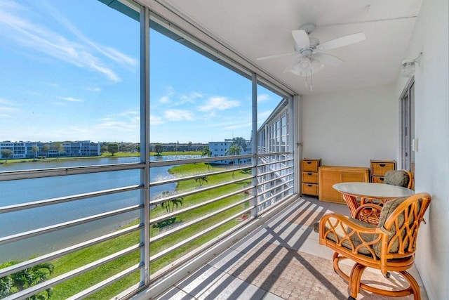 sunroom with a water view and ceiling fan