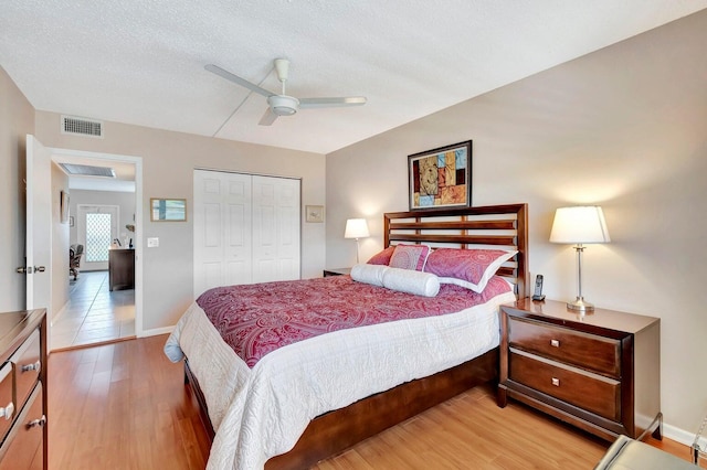 bedroom featuring ceiling fan, a closet, hardwood / wood-style floors, and a textured ceiling