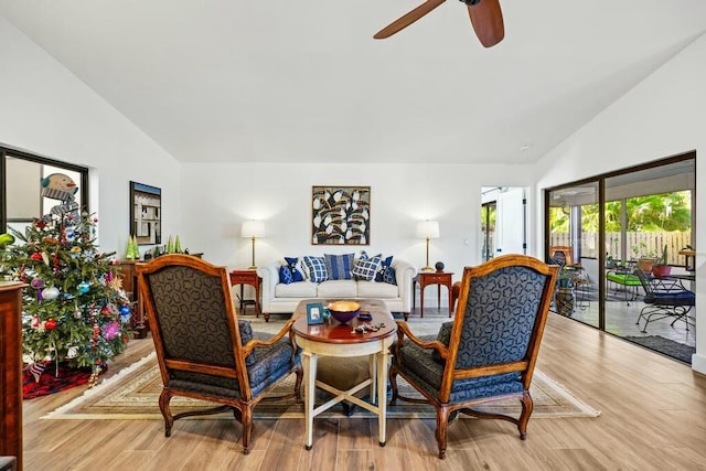 living room featuring ceiling fan, light hardwood / wood-style flooring, and high vaulted ceiling